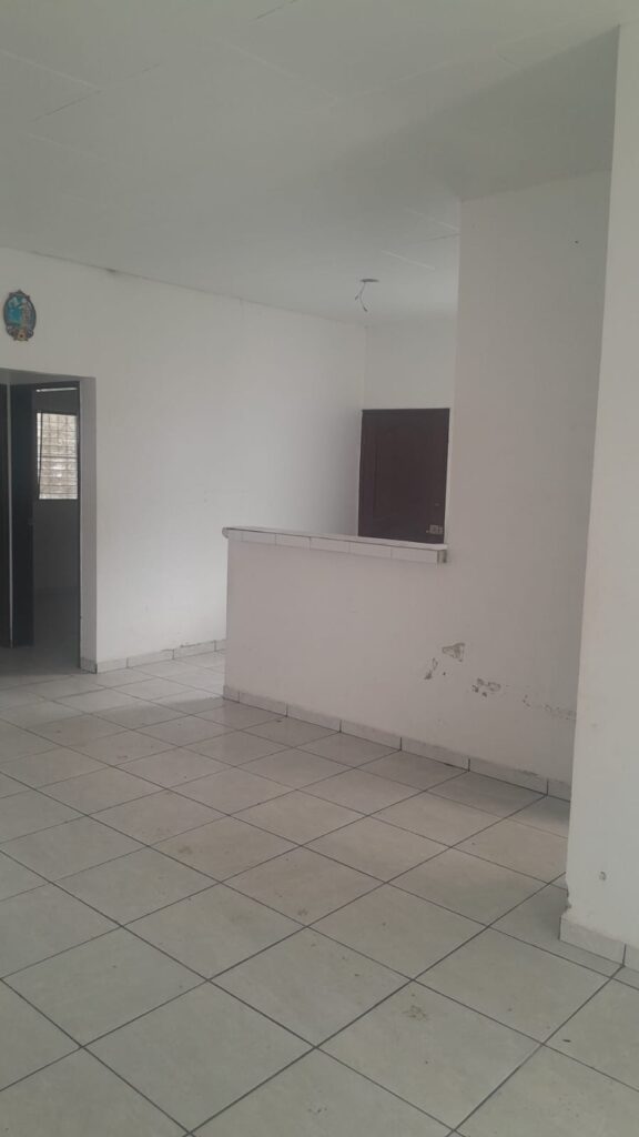 Vista interior de la casa con entrada al dormitorio y área de cocina con barra