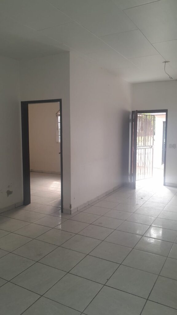 Vista interior con acceso a habitación y puerta principal de salida