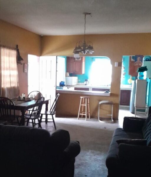 Sala y comedor integrados con vista hacia la cocina en casa de venta en Olanchito