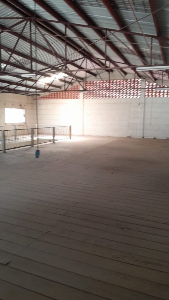Imagen de la segunda planta del local comercial en Olanchito, espacio amplio con piso de madera, barandales y buena iluminación natural.