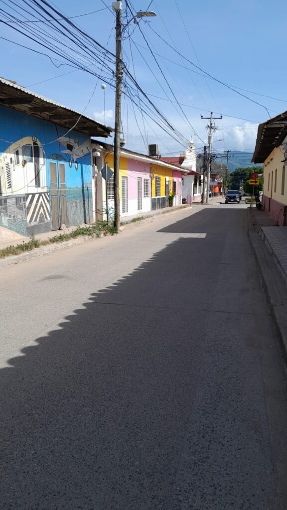 Calle pavimentada en el centro de Olanchito, con comercios y vista a la iglesia católica al fondo. Zona comercial de alta plusvalía.