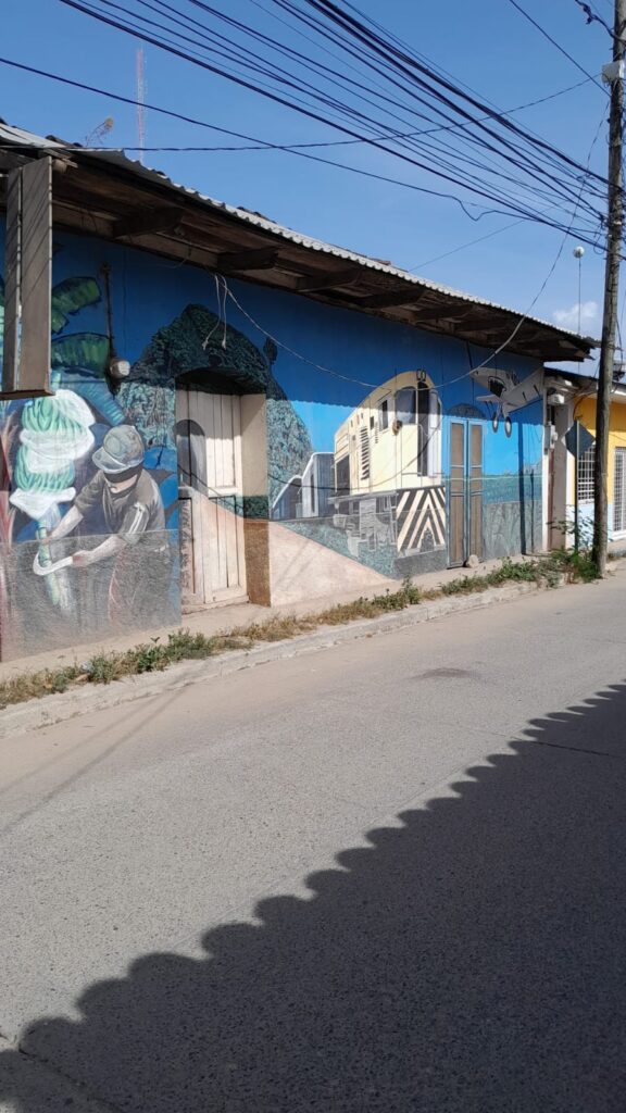 Fachada de propiedad con mural colorido en venta como terreno urbano en el centro de Olanchito, Honduras.