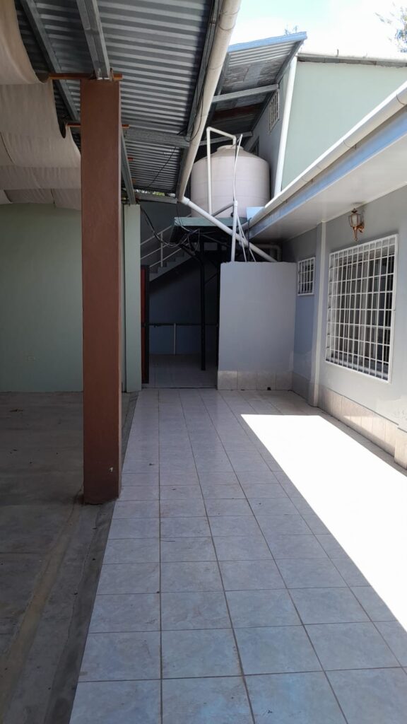 Área interna de local comercial en venta en Olanchito con piso cerámico, cisterna y acceso a segundo nivel