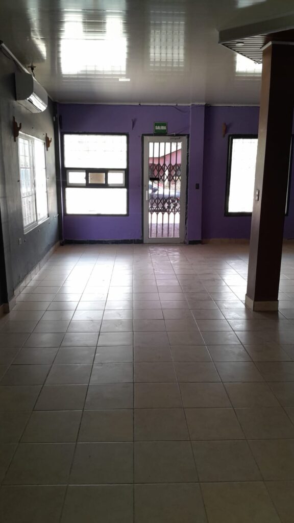 "Interior de local comercial en venta en Olanchito, con piso cerámico, ventanales y salida directa a la calle
